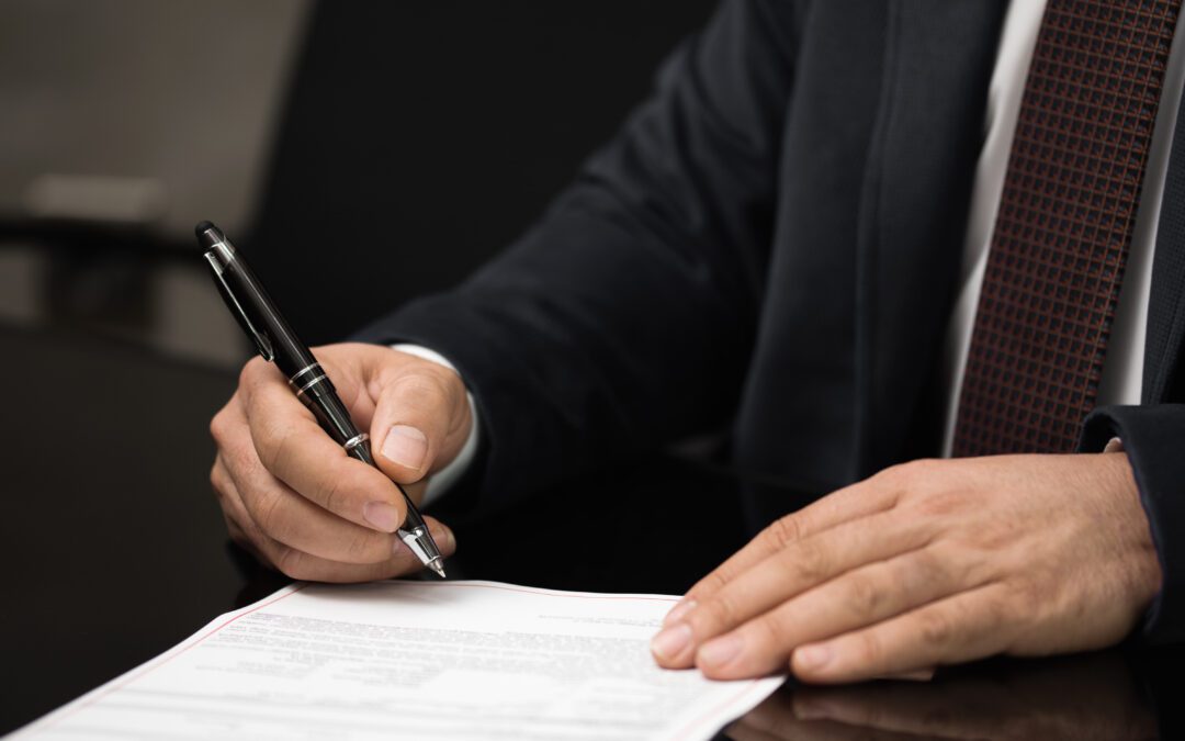 Hands with a pen writing a business letter.