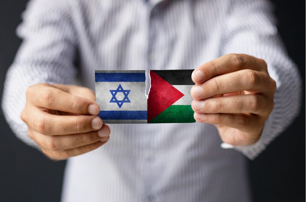 Man holding flags of Israel and Palestine